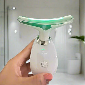 Black handheld device lit up for anti ageing skincare treatment