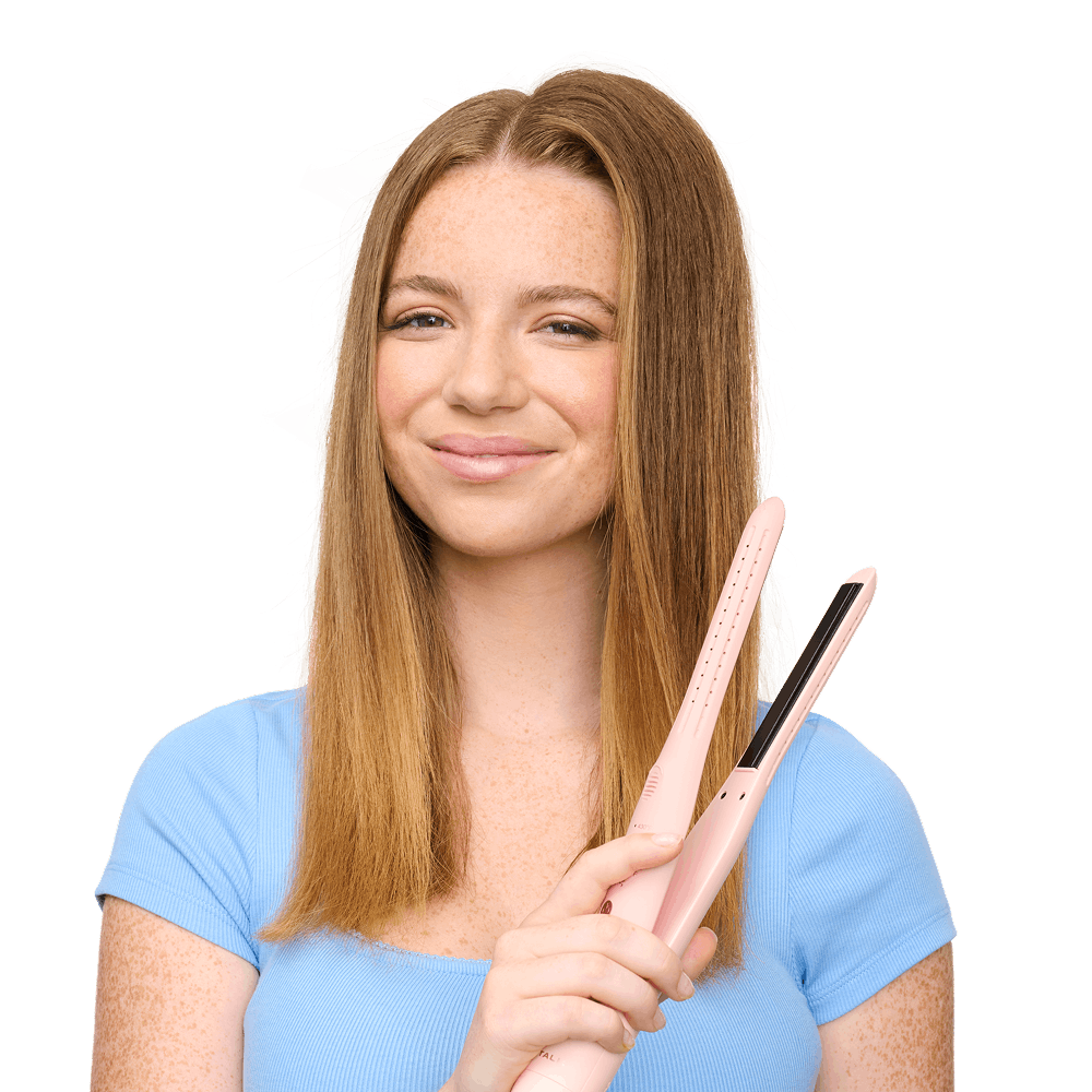 Woman holding a hair straightener with a plain background