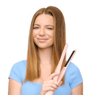 Woman holding a hair straightener with a plain background