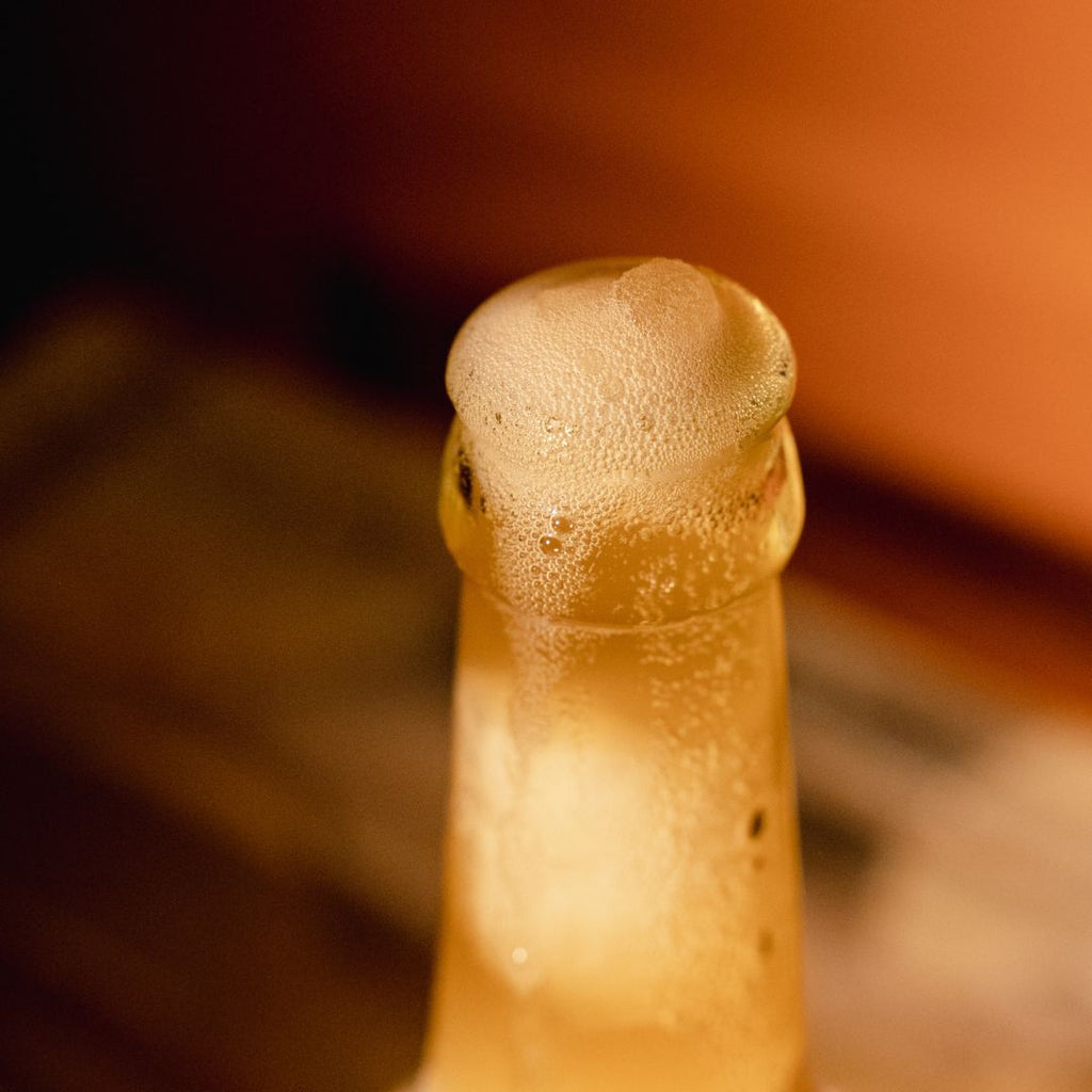 Close-up of a bottle cap with condensation on a blurred background