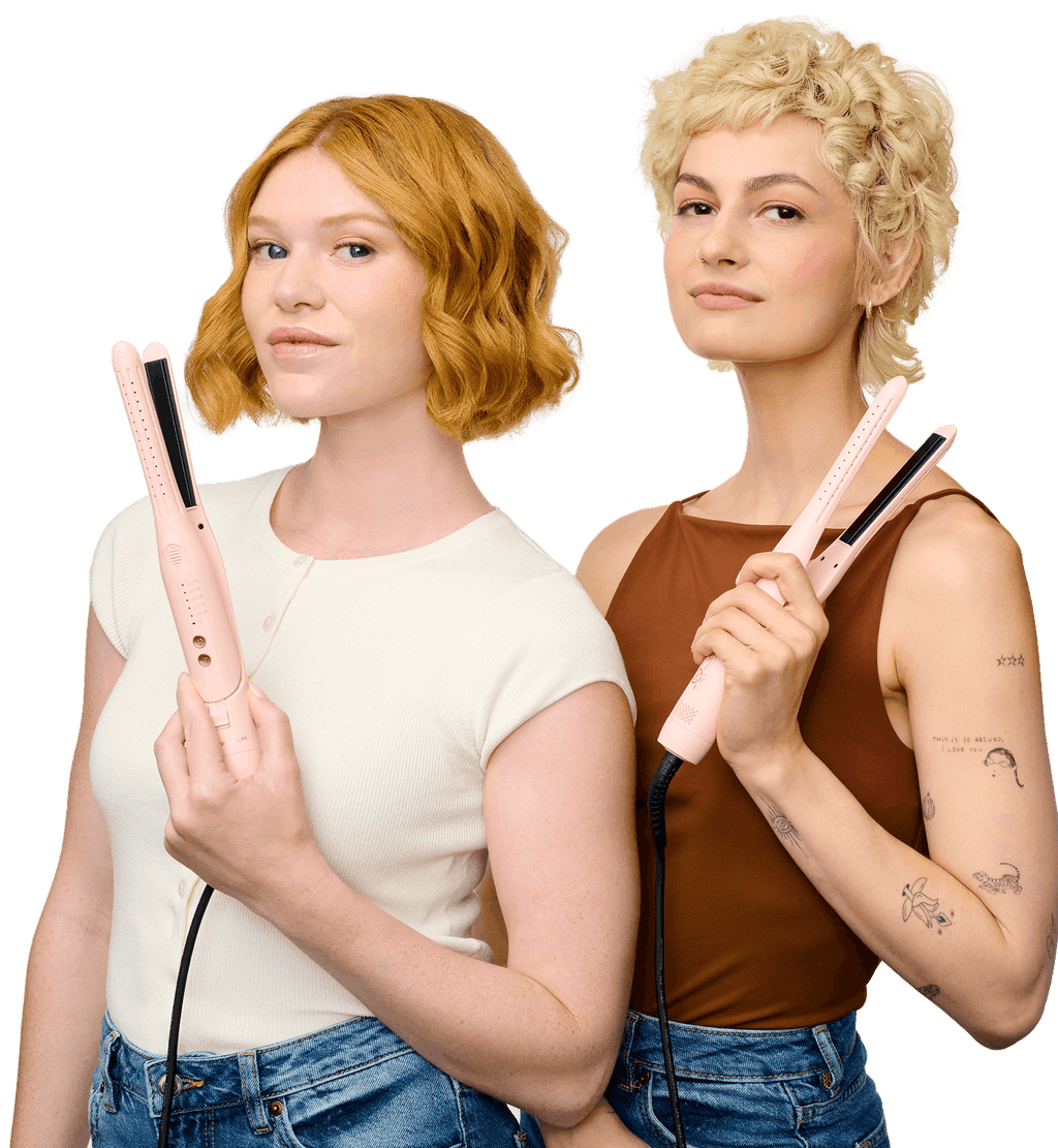 Two women holding pink hair straighteners against a white background