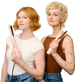 Two women holding pink hair straighteners against a white background