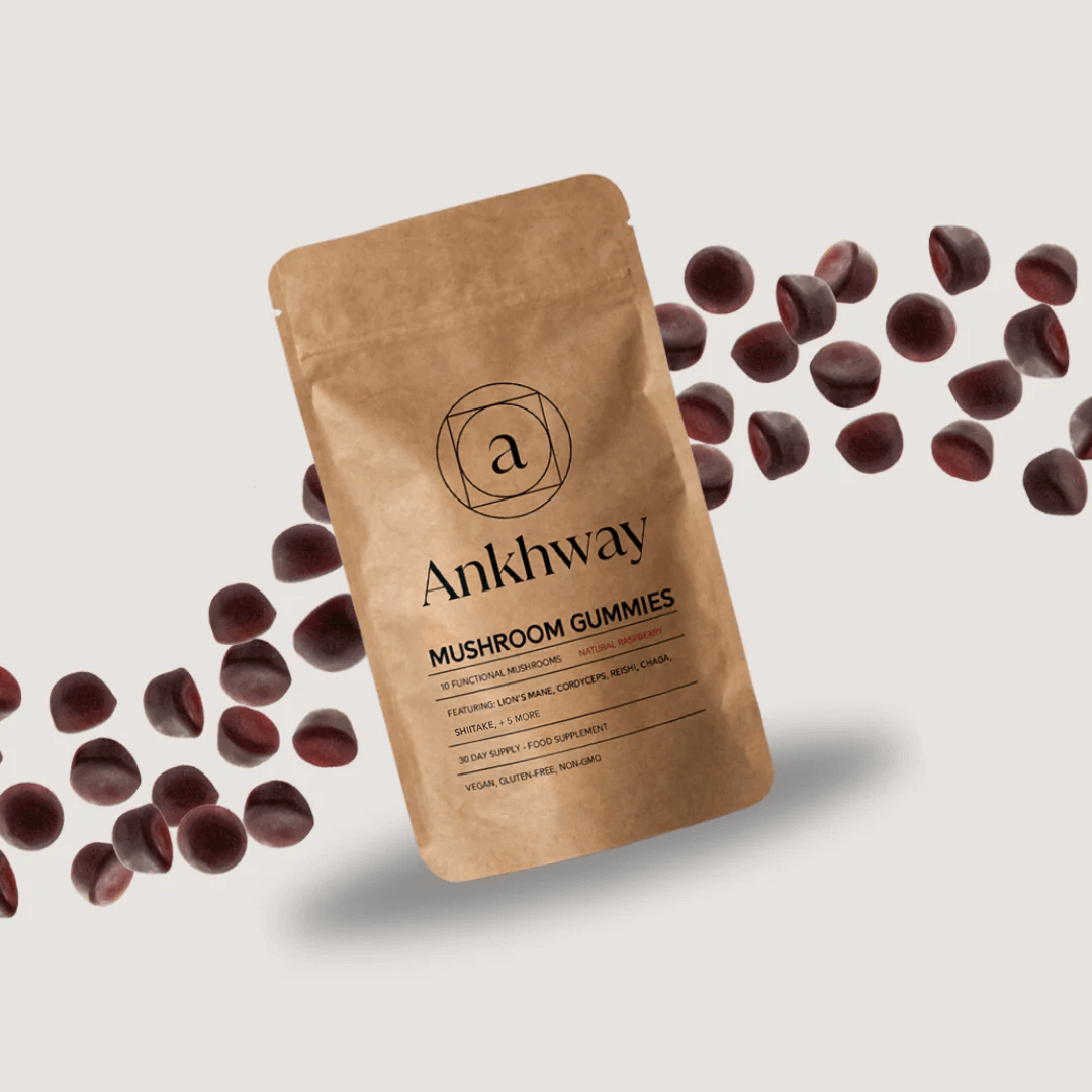 Brown package labeled 'Ankhway Mushroom Gummies' surrounded by scattered dark gummies.