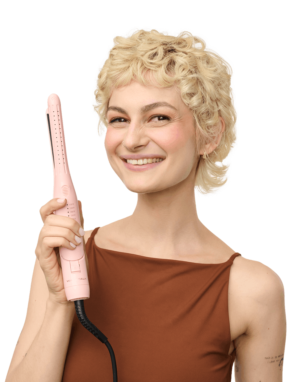 Woman with styled hair holding a pink hair straightener against a black background