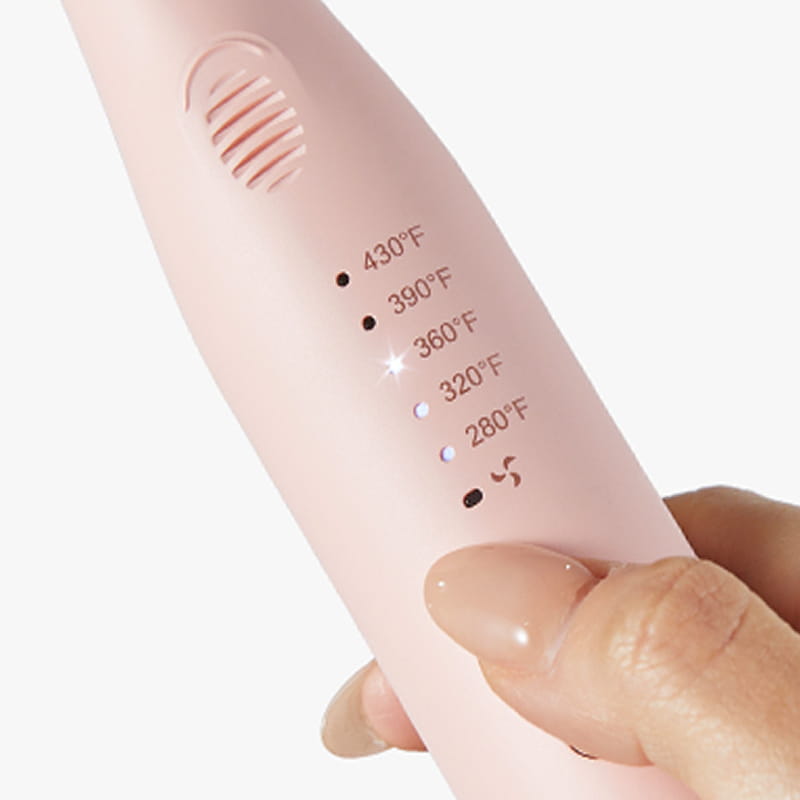 Pink kitchen tool with temperature markings held by a hand on a white background