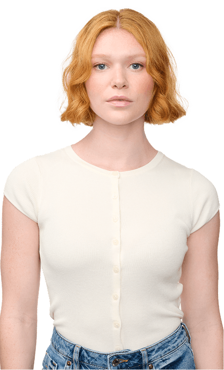 Person wearing a white top and blue jeans with a plain background
