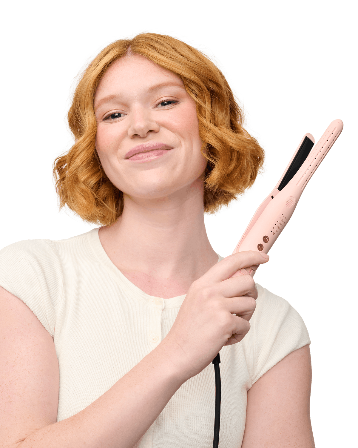 Woman with red hair holding a pink hair straightener against a black background
