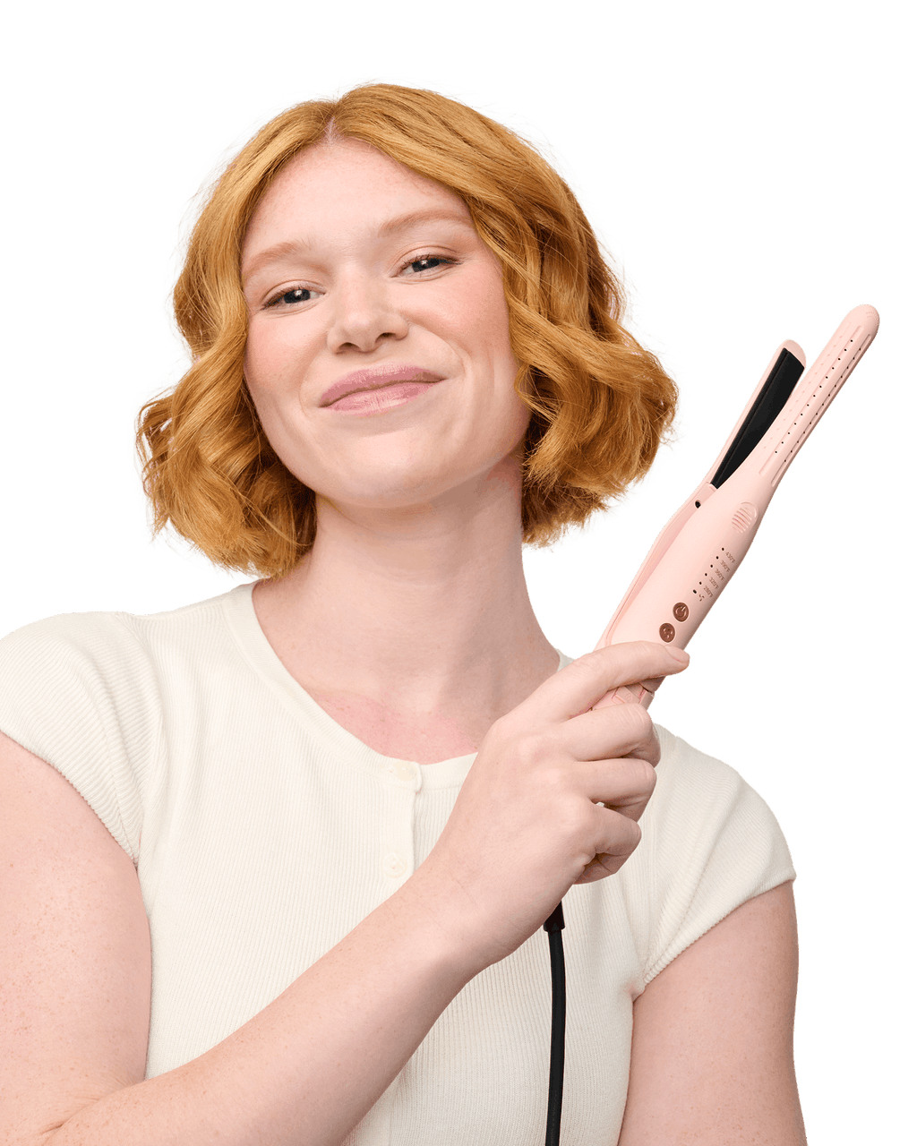 Woman with red hair holding a pink hair straightener against a black background