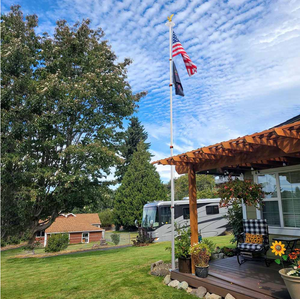 Telescoping flagpole kit with American flag display at night, featuring solar-powered LED lights.
